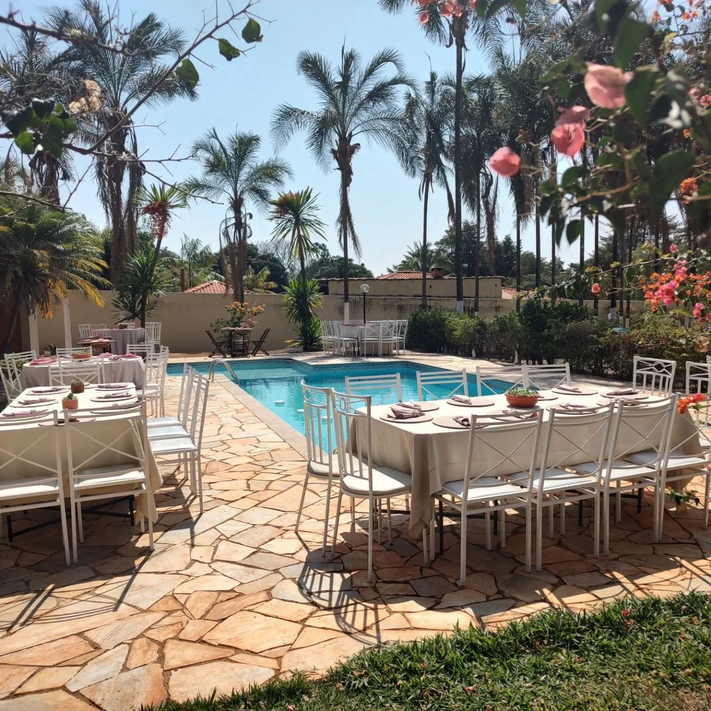 Piscina e jardim com mesas decoradas